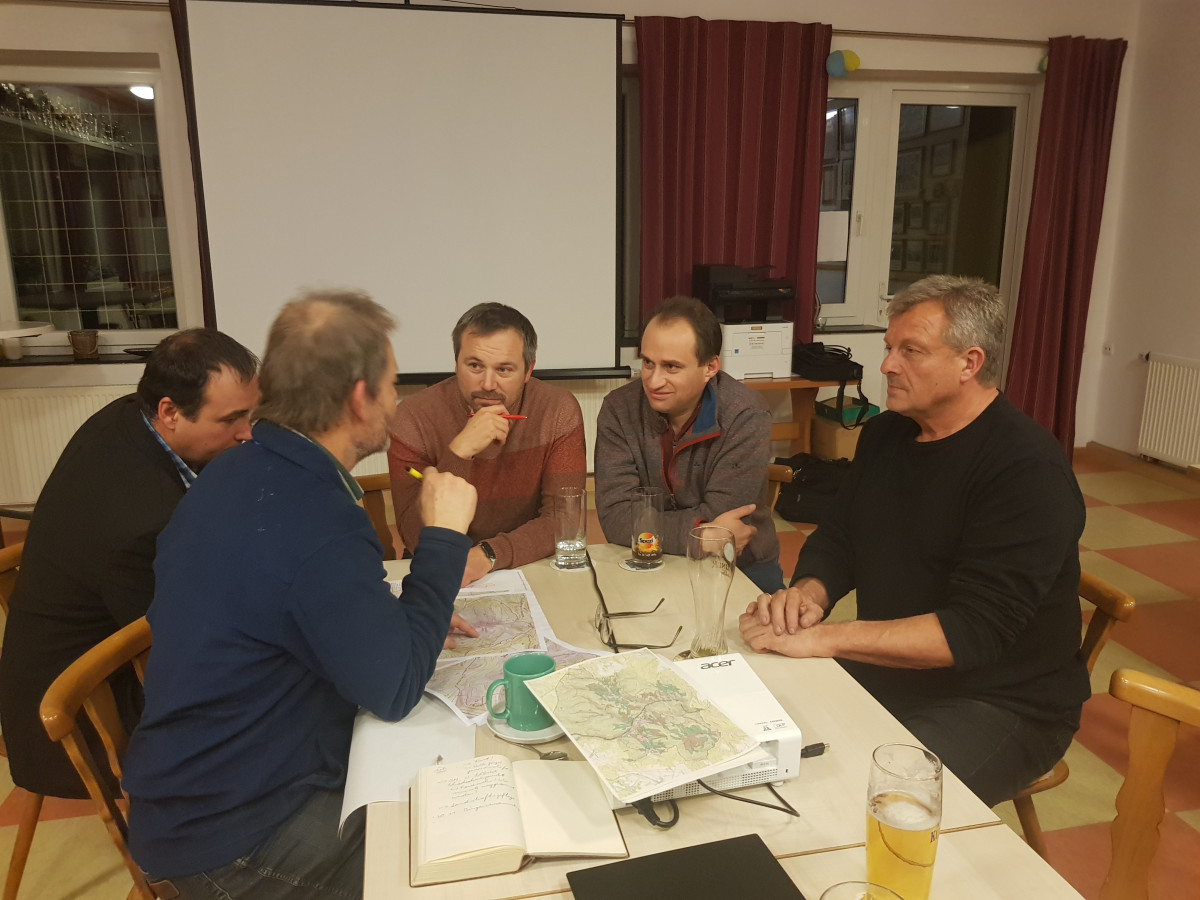 Foto: 5 Personen sitzen an einem Tisch in einem Raum auf dem Tisch liegen Karten vom Projektgebiet