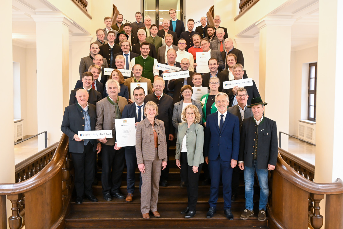 Auf der Freitreppe im Landwirtschaftsministerium stehen viele lachende Menschen und halten Ihre Urkunden sowie Schilder mit der Aufschrift