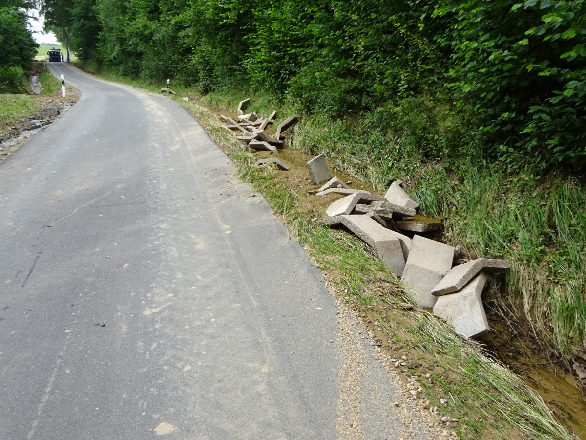 Straße mit ausgespültem Wegseitengraben