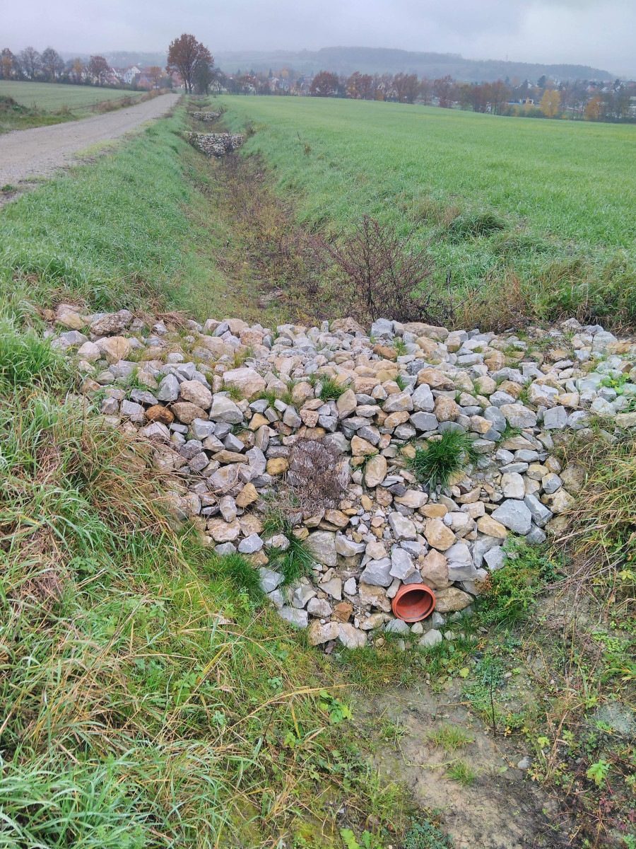 Rückhalt statt Beschleunigung - Gräben können auch anders. Steinschüttung in einem Wegseitengraben östlich von Diespeck
